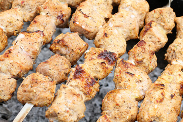 Pork barbecue on skewers frying on a grill brazier. Closeup