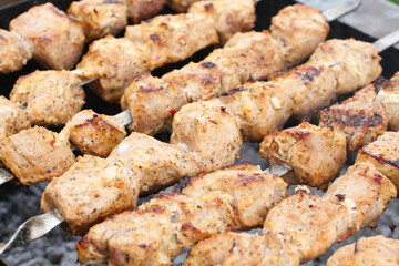 Pork barbecue on skewers frying on a grill brazier. Closeup