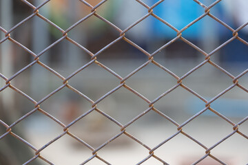 Fototapeta premium Old mesh wire fence with blurred background.