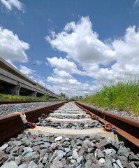 On the right track, large white clouds in blue sky