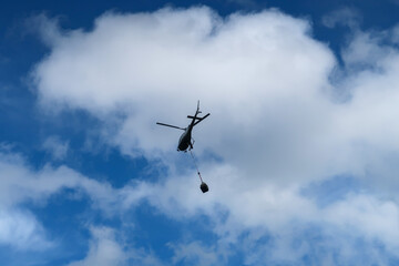 Fototapeta na wymiar 山小屋へ荷物を輸送するヘリコプター
