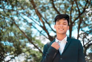 A handsome and young Filipino college student in smart casual wear. Smiling and friendly vibe. At...