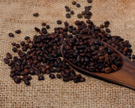 Concept wallpaper for coffee shop. Scattered coffee beans combined with a plain background. The texture of the coffee beans is very striking. Template background for mockup design. Focus blur.