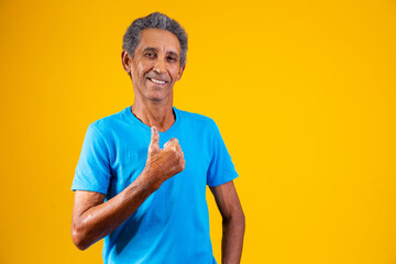 elderly man with thumb up giving thumbs up.