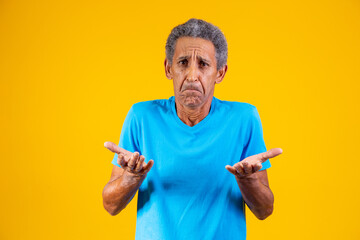Handsome afro middle aged senior man on isolated yellow background clueless and confused expression...