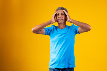 Forgotten and confused elderly afro man on yellow background.