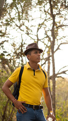 Outdoor portrait of a Hispanic man with jean pants, yellow t-shirt and hat coffee.