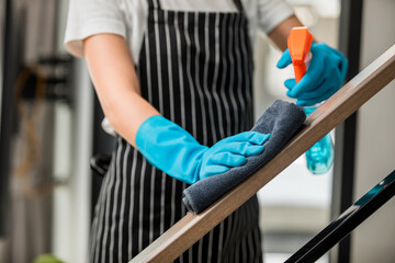 Close up, Housekeeper cleaning railing using alcohol and sanitizer to prevent coronavirus (COVID-19) infection, disinfection and hygiene concept. - obrazy, fototapety, plakaty