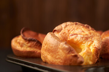 Fresh cooked yorkshire puddings on a  wooden background.