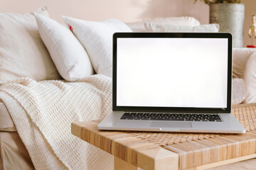 Home office desk. Laptop with blank screen on a desktop in modern living room in beige colors.