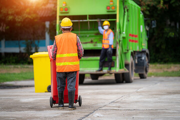 Workers in the street are loading a garbage truck,Garbage Bin Collection,Waste collector with...