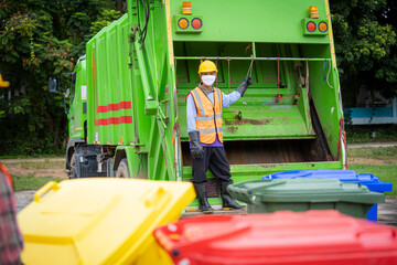 Garbage men working together on emptying dustbins for trash removal with truck loading waste and...