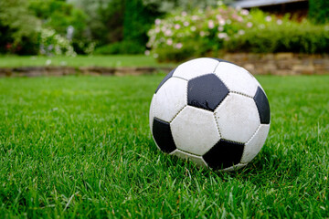 Fototapeta premium Close-up view of football ball on green grass lawn