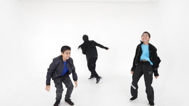 Crazy happy group of Asian kids performs greeting with hands and dancing jumping together having fun on white background.
