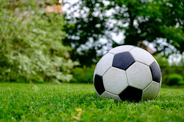 Fototapeta premium Close-up view of football ball on green grass lawn