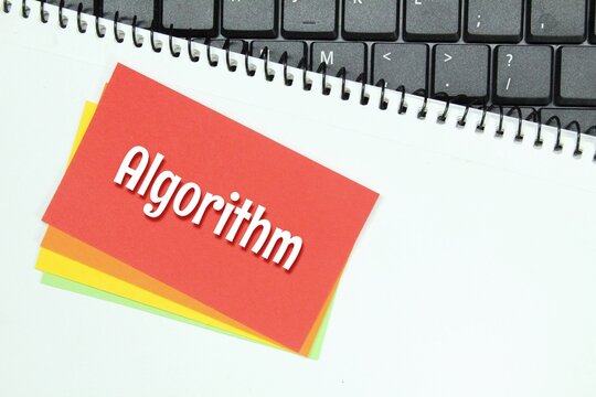 colored paper, white paper, laptop keyboard with word algorithm