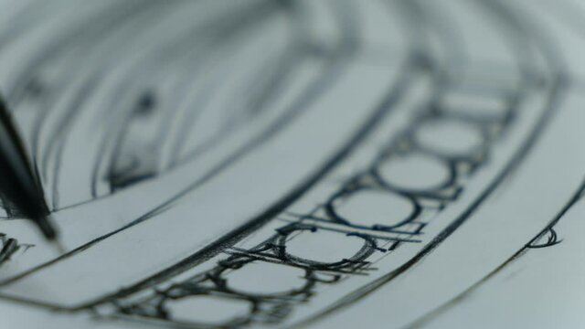 Craft goldsmith work. Portrait of young jeweler drawing a sketch of a new ring. Concept of: wedding, luxury, jewelry