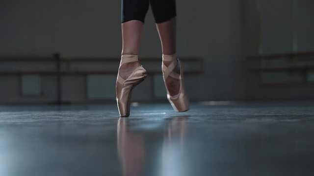 Professional woman ballerina walking on the tips of her pointe shoes