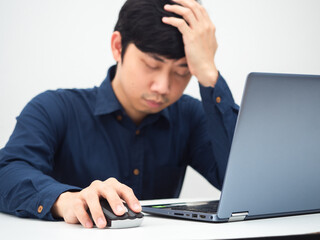 Man working from home with laptop on the table and feeling strian touch his head