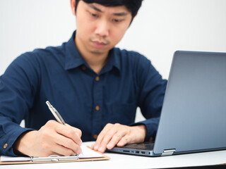 Man writing document board the table and using laptop working from home concept