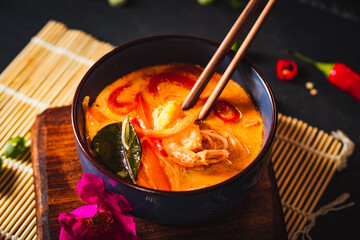 Coconut soup with shrimps and rice pasta. Hot bowl of exotic soup.