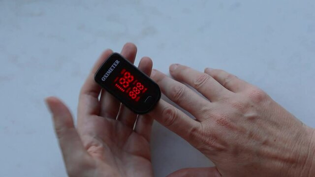 Measuring of Oxygen level in blood with home oximeter, Oximeter in woman`s hands