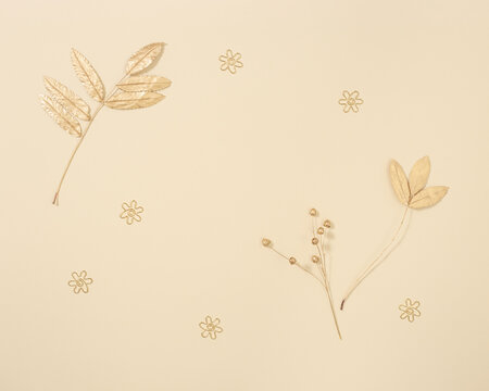 Autumn composition with autumn leaves of rowan in gold color on neutral beige background. Fall time concept
