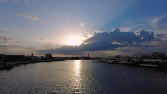 Time lapse of Bangkok cityscape view and Chao Phraya river at sunset, View from Phra Phuttha Yodfa Bridge in Bangkok Thailand.