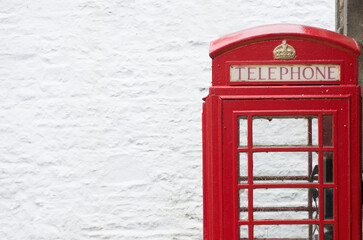 Obraz premium red british telephone box against a white wall