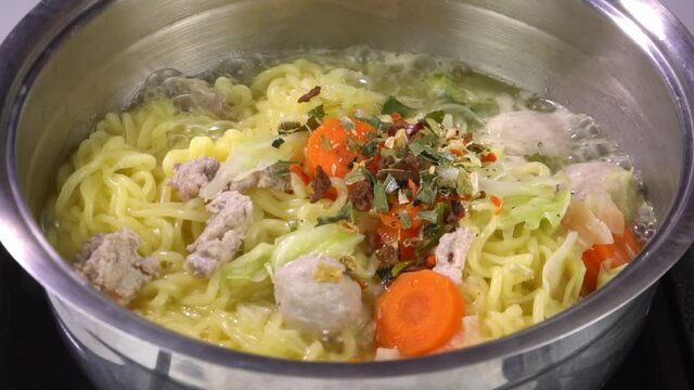 pour  seasoning on boiled instant noodle in the pot  slow-motion video


