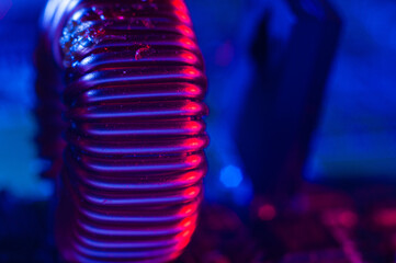 Single copper induction coil with copper wire on electronic PCB close up in red and blue lighting