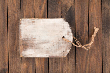 Old shabby wooden cutting board on a wooden background
