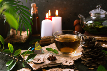 Wooden runes are lying on the table among the papers with notes. There is a mug of tea next to it. Astrology and esotericism. Esoteric breakfast.