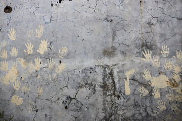 Cracked gray wall background texture with hand print