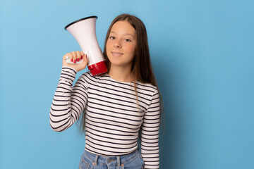 Young girl holding megaphone isolated over blue background.