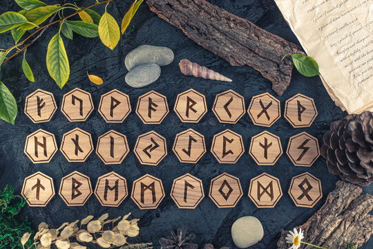 Wooden runes are lying on the table among various objects. Astrology and esotericism. Senior Futhark