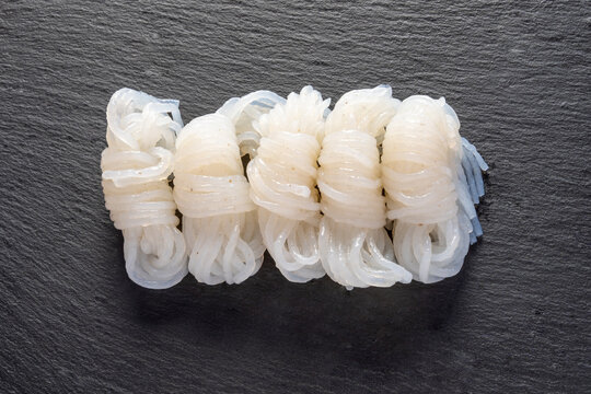 しらたき・コンニャクから作った麺状の食材（石製スレートプレート・黒背景）