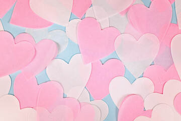 Pink and white heart shaped paper confetti on light blue background