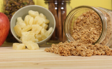 Honey With Granola, Dried Pineapple and Apples in Rustic Kitchen