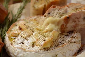 Baked camembert with toasts , rosemary on white cooking paper