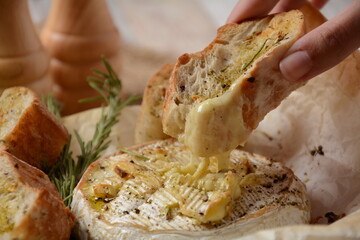 Baked camembert with toasts , rosemary on white cooking paper