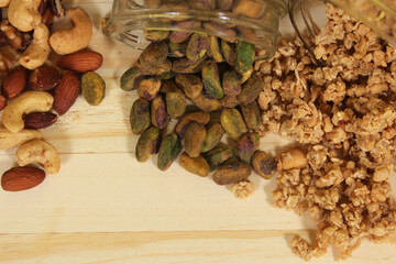 Pistachios and Mixed Nuts With Granola on Wooden Table