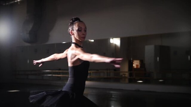 Ballet dancing - woman ballerina in black tutu training her dancing in the mirror studio - spinning