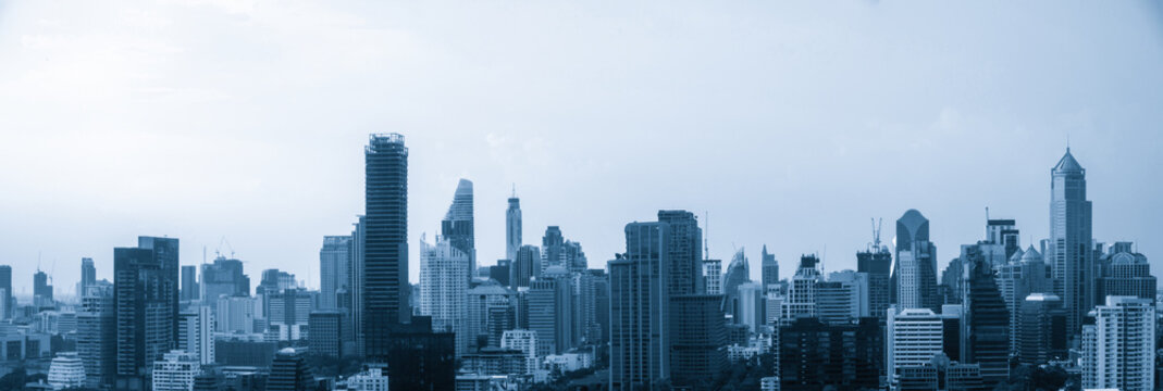Fototapeta Blue-filtered cityscape and high-rise buildings in metropolis city center . Downtown business district in panoramic view .