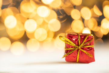 christmas present red and silver baubles against bokeh lights gold shiny glitter background with copy space