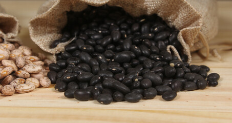 Dried Pinto Beans and Black Beans in Burlap Bag on Wooden Background