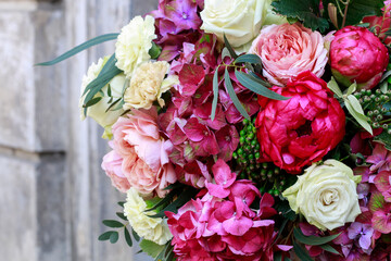 Wedding floral decoration with roses, peonies, hortensias, carnations and other flowers.