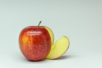 Apple and its slice on light background