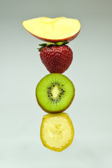 Apple, strawberry, kiwi and banana on light background