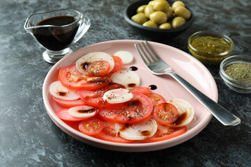 Concept of tasty food with tomato carpaccio on black smokey table